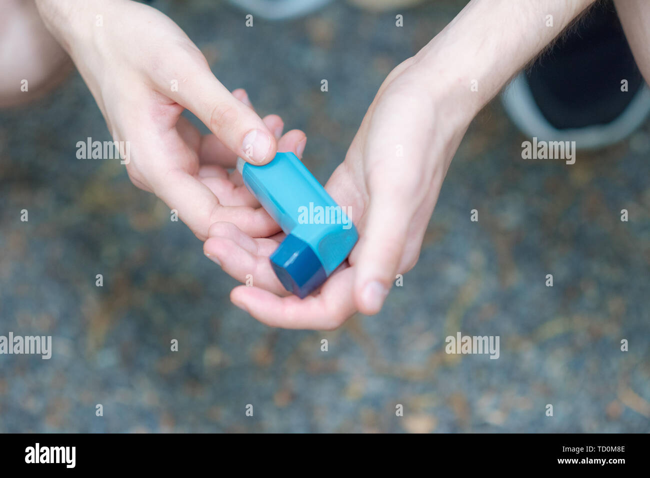 Asma medecine inalatore sostenuto da due mani di un uomo Foto Stock