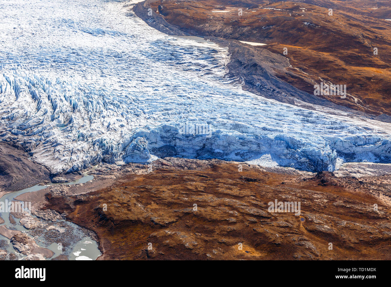 Groenlandese tappo di ghiaccio del ghiacciaio di fusione con la tundra vista aerea, vicino a Kangerlussuaq in Groenlandia Foto Stock