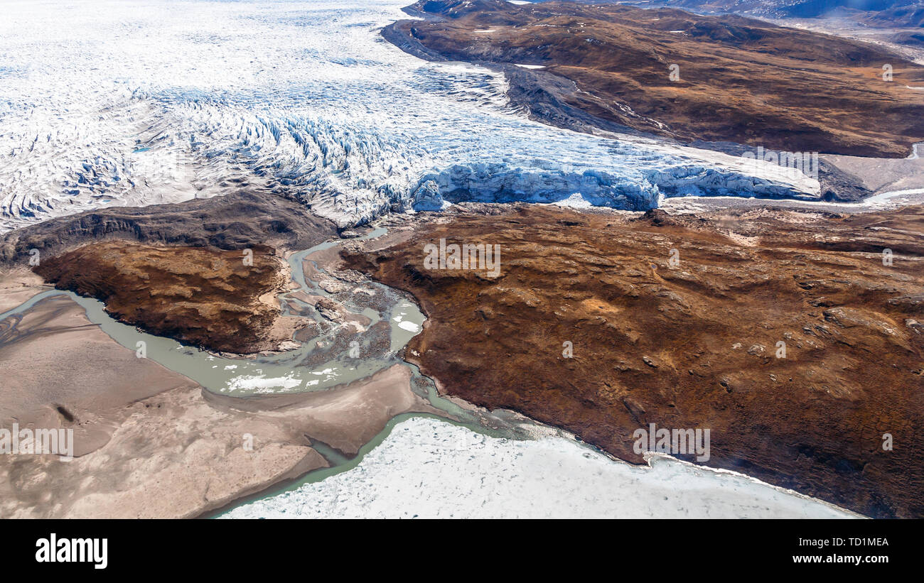 Groenlandese lastra di ghiaccio del ghiacciaio di fusione nel fiume con la tundra vista aerea, vicino a Kangerlussuaq in Groenlandia Foto Stock