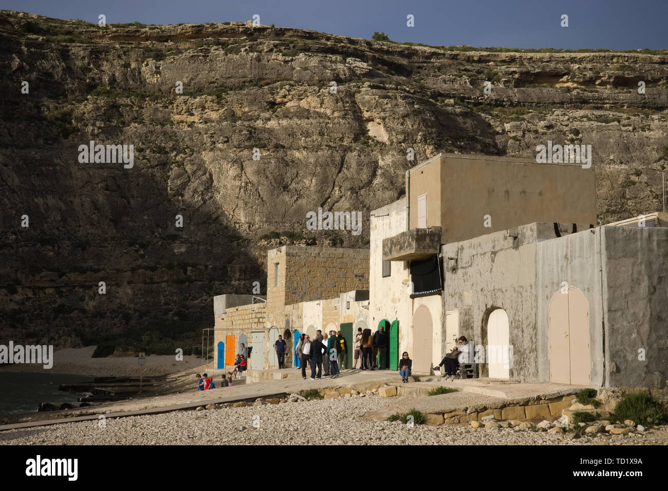 Isola di Gozo, Malta - Maggio 2019: gruppo di persone in attesa sul molo di mare interno (punto di immersione) a guardare attraverso l'apertura nella roccia. Foto Stock