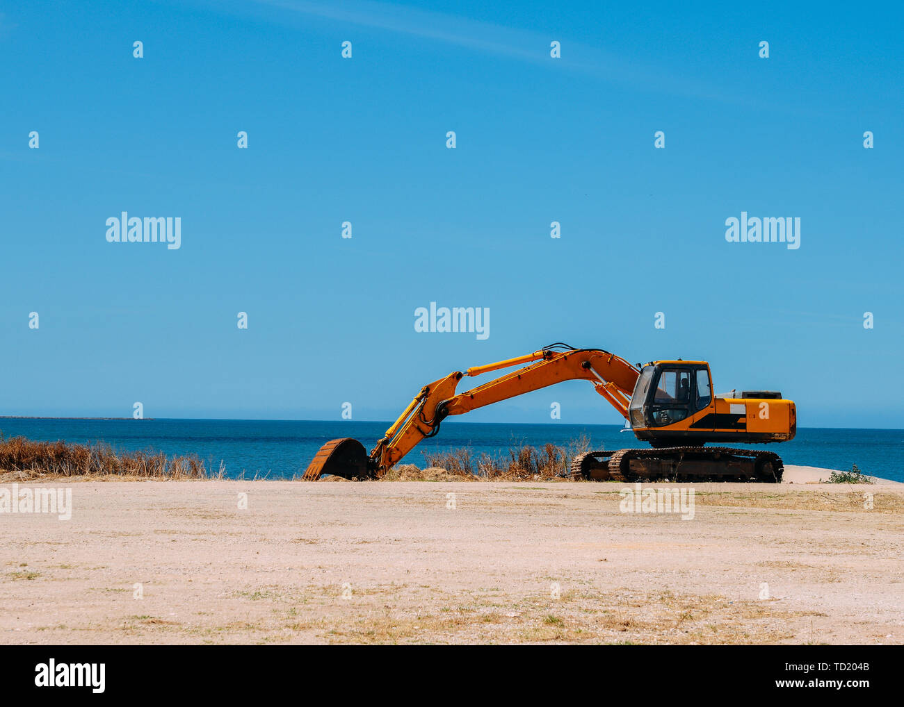 Bulldozer giallo lavorando su una spiaggia con una copia dello spazio. Foto Stock