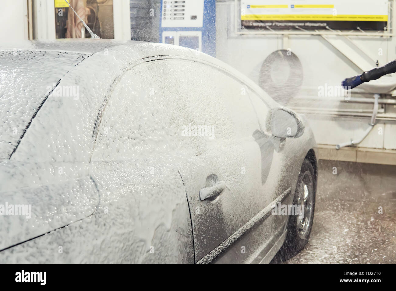 Auto è ricoperta di schiuma per lavare la macchina. Stazione di lavaggio automatico. Shampoo per auto. Processo di pulizia Foto Stock