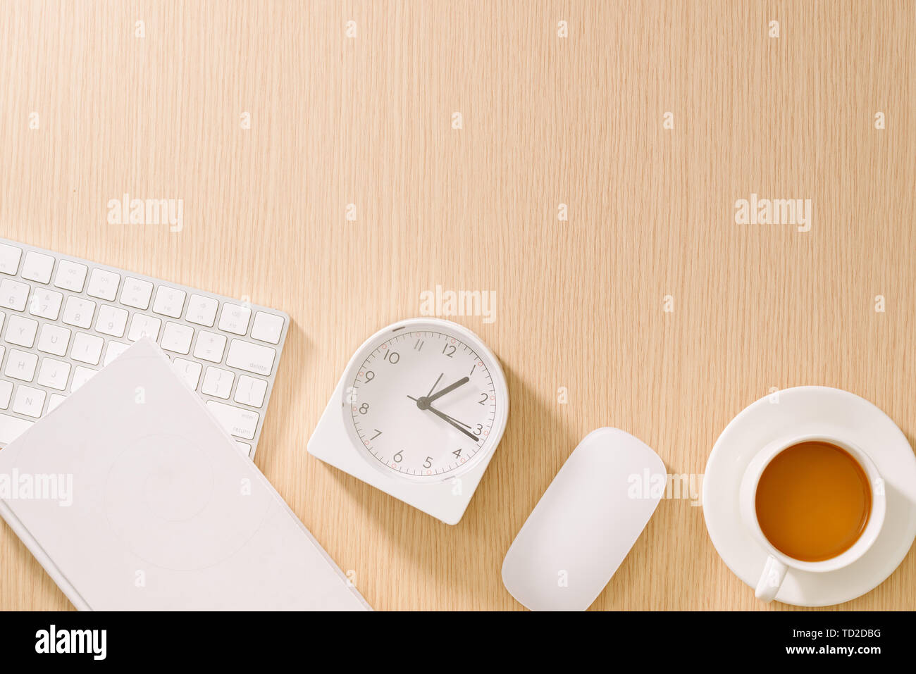 Bianca e moderna scrivania da ufficio con tastiera, mouse, notebook, orologio e la tazza di caffè. Vista da sopra con copia incolla. Attività e strategia concetto mockup. Foto Stock