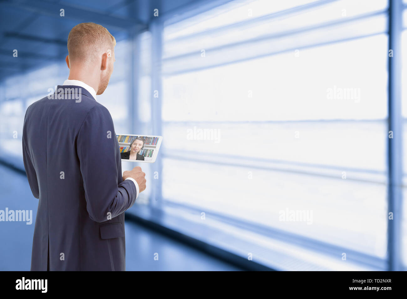 Uomo con tablet pc parlando a un collega di lavoro in ufficio in casa il concetto di telelavoro. Foto Stock