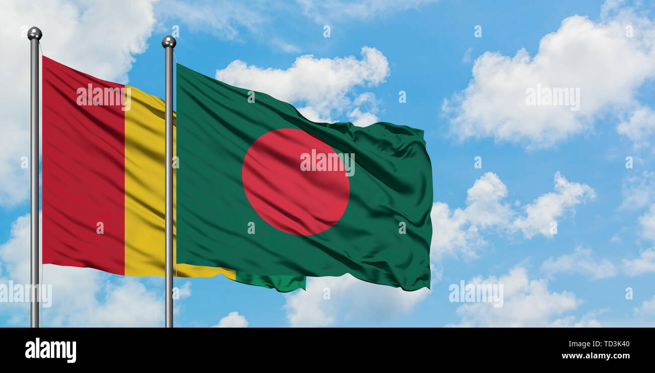 La Guinea e il Bangladesh bandiera sventolare nel vento contro bianco torbido cielo blu insieme. Concetto di Diplomazia e relazioni internazionali. Foto Stock