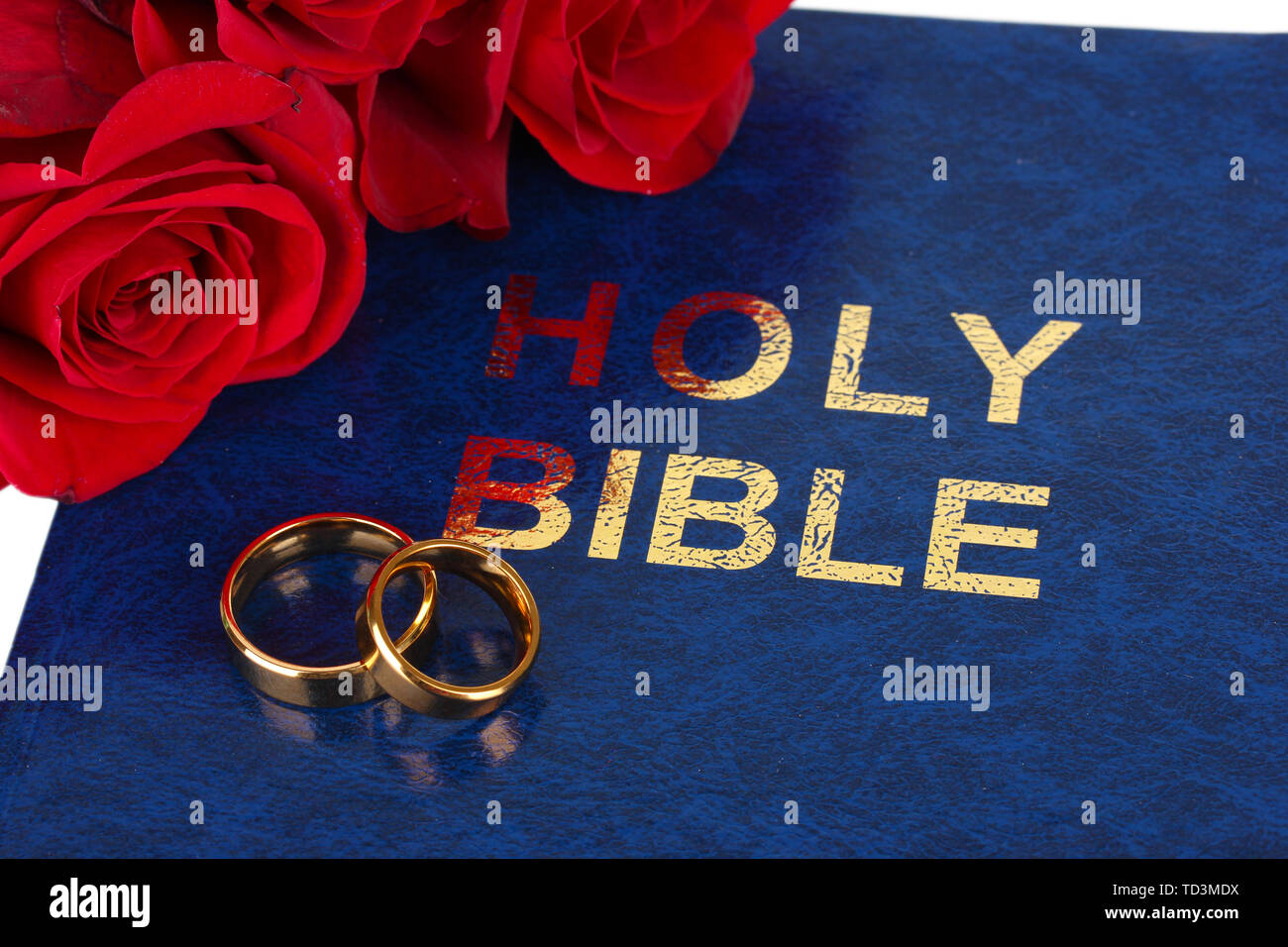Gli anelli di nozze con rose sulla bibbia Foto Stock