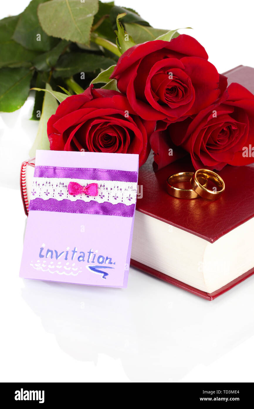 Gli anelli di nozze con rose e biglietto di auguri sulla bibbia isolato su bianco Foto Stock