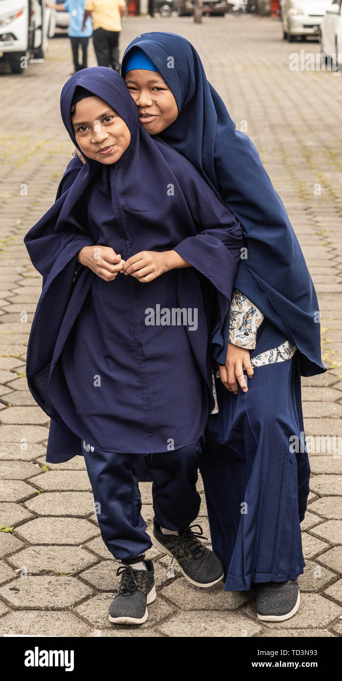 Makassar, Sulawesi, Indonesia - 28 Febbraio 2019: Closeup ritratto di due giovani ragazze Muslima, sia coperto in blu Khimar solo mostrando il viso e le mani Foto Stock