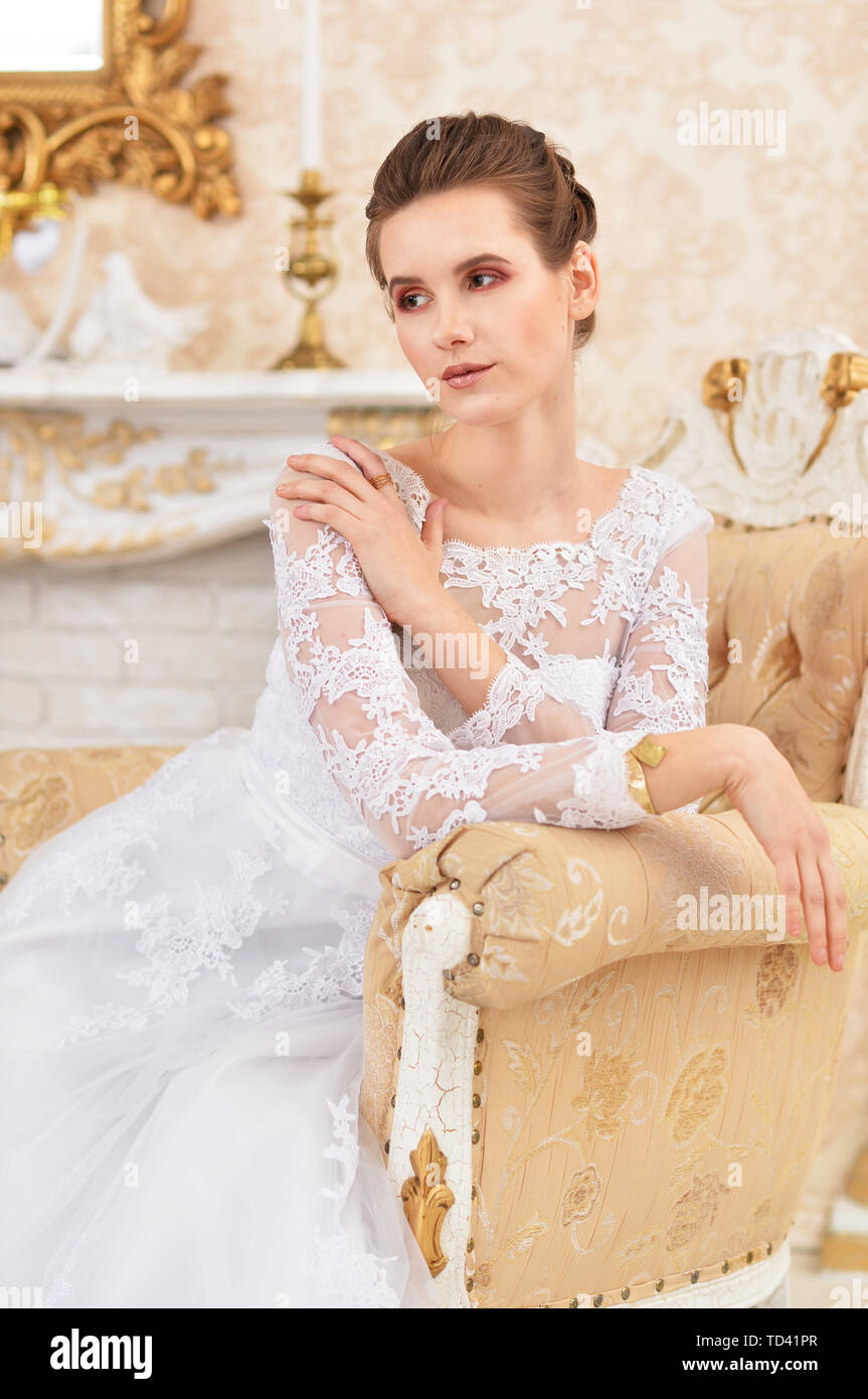 Giovane donna sposa seduti su una sedia in camera wintage Foto Stock