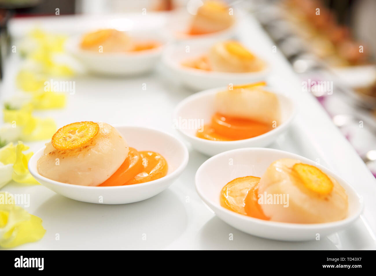 Cappesante fritte con marmellata di arancione sulla piastra, primo piano Foto Stock