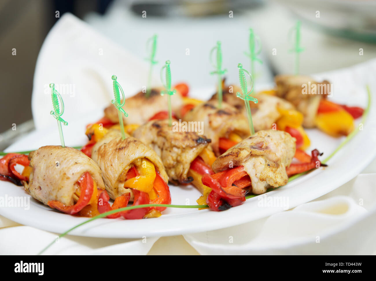 Involtini di pollo con il peperone su piastra di porcellana Foto Stock