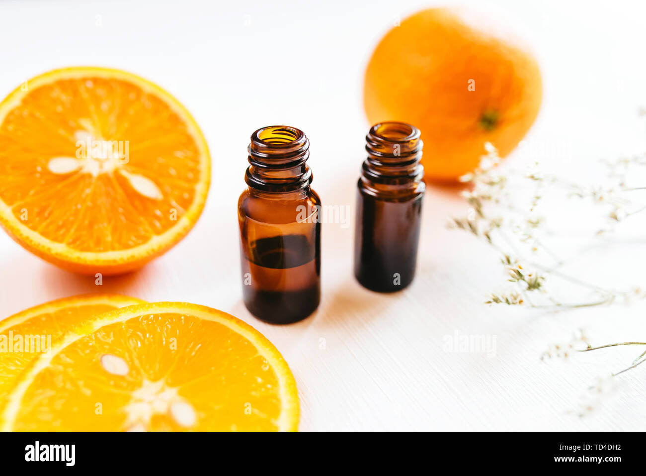 Due bottiglie di olio essenziale di Arancio su sfondo bianco per la bellezza e la cura della pelle, wellness e scopi medicinali. Foto Stock