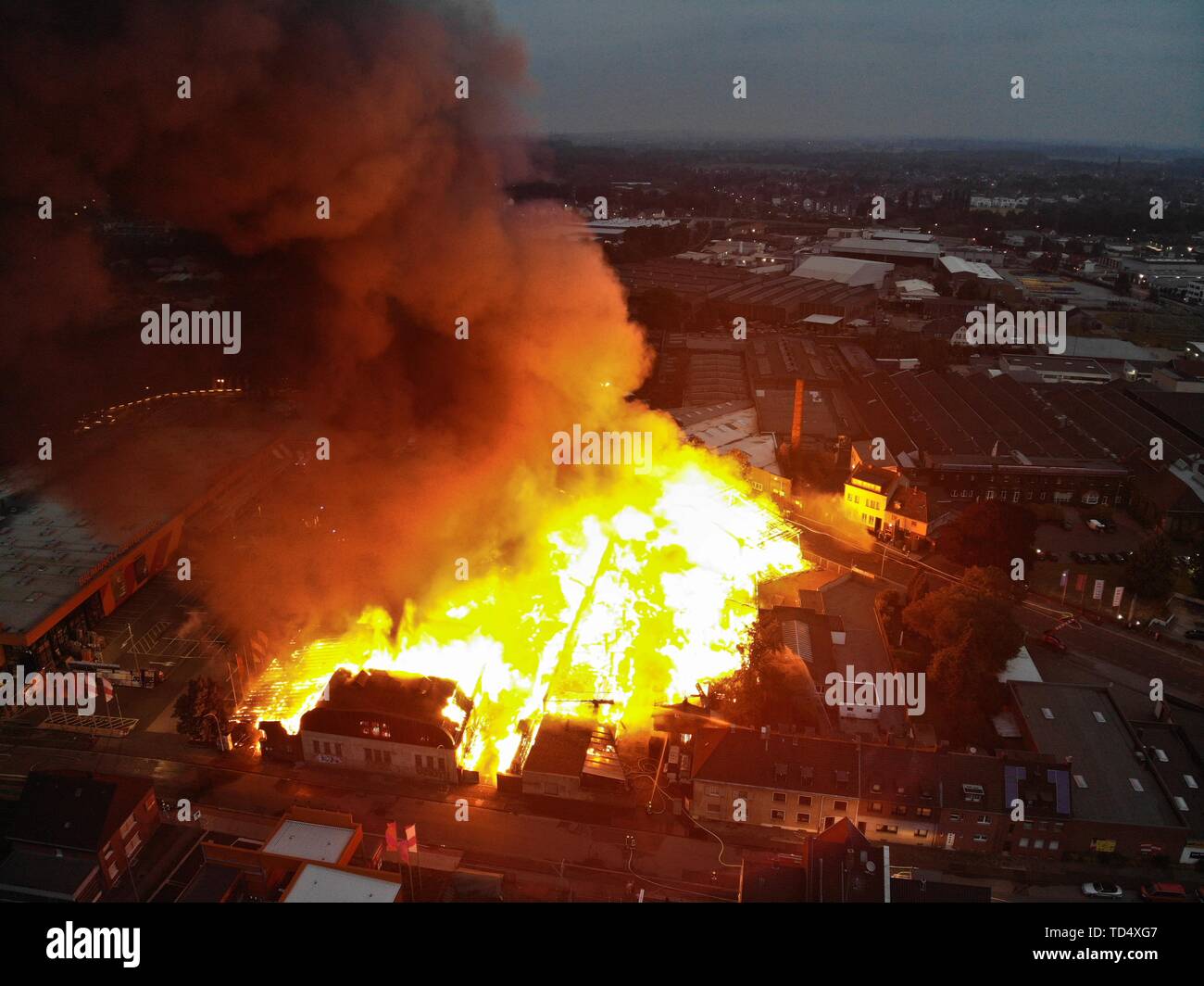 14 settembre 2017, della Renania settentrionale-Vestfalia, Mönchengladbach: Luminose fiamme sono la rottura di un complesso di edifici nel quartiere Eicken (fotografia aerea con drone). Il fuoco era scoppiata nella zona in cui accanto a un laboratorio di falegnameria anche ancora ulteriormente le imprese sono alloggiati. Foto: Sascha Rixkens/dpa Foto Stock