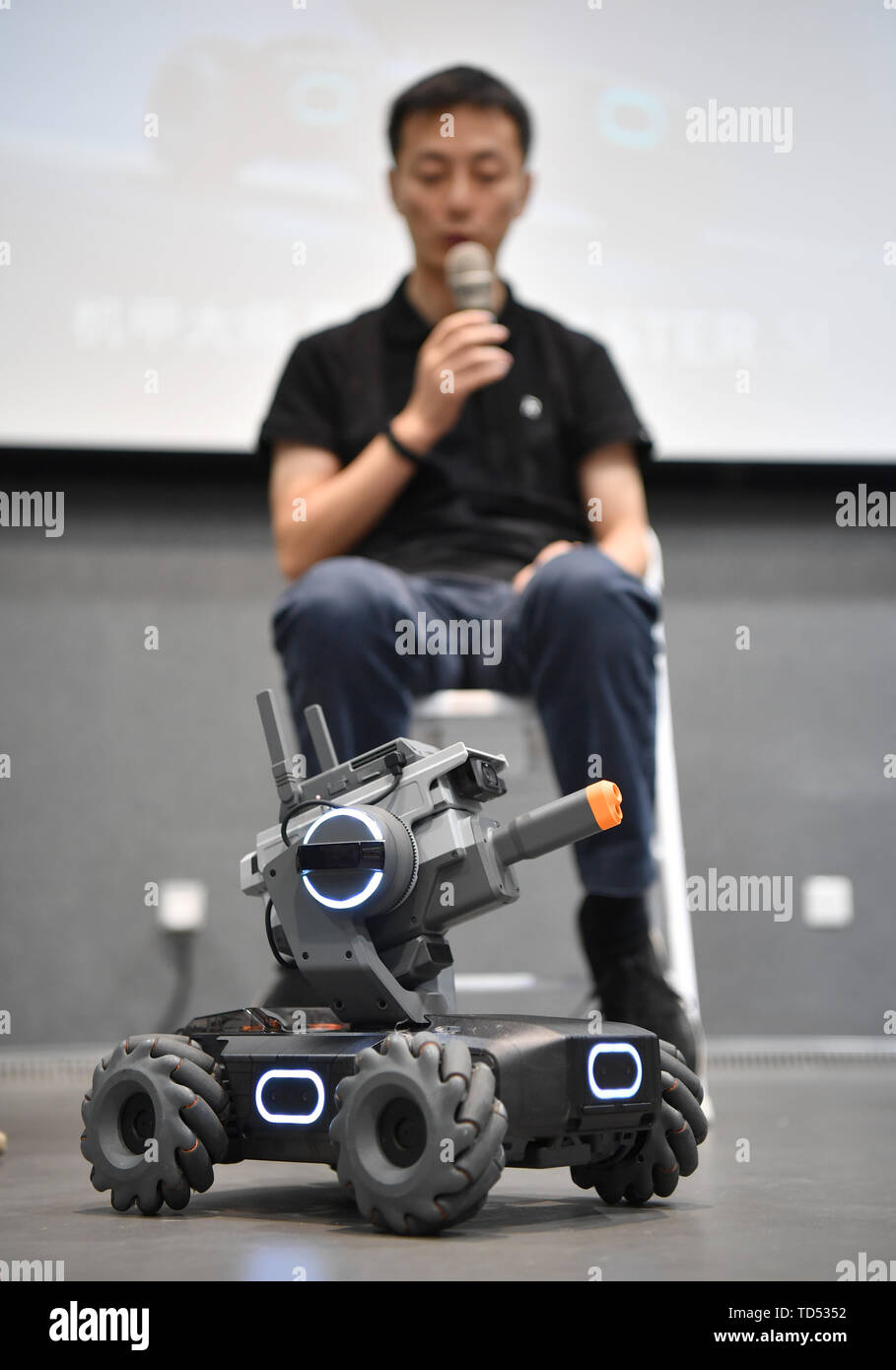 Pechino, Cina. 12 Giugno, 2019. Un membro del personale spiega come un robot educative prodotte dai cinesi drone maker DJI reagisce ad un evento a Pechino Capitale della Cina, 12 giugno 2019. DJI ha lanciato il suo primo robot educativo RoboMaster S1 in corrispondenza di un evento di mercoledì. Il robot 2 di supporto dei linguaggi di programmazione, dispone di una configurazione dei sensori 31 e 46 i componenti programmabili. Credito: Wang Qingqin/Xinhua/Alamy Live News Foto Stock