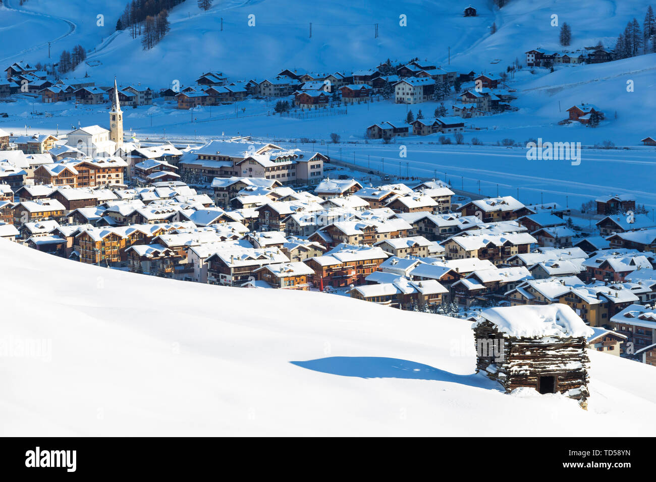Villaggio illuminato dal sole dopo una nevicata, Livigno Valtellina, Lombardia, Italia, Europa Foto Stock