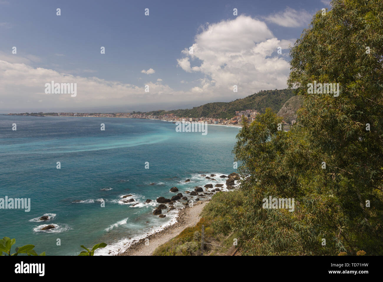 Giardini Naxos Sicilia panorama del litorale e bay, uno splendido mare con alcune rocce, alberi e colline verdi Foto Stock