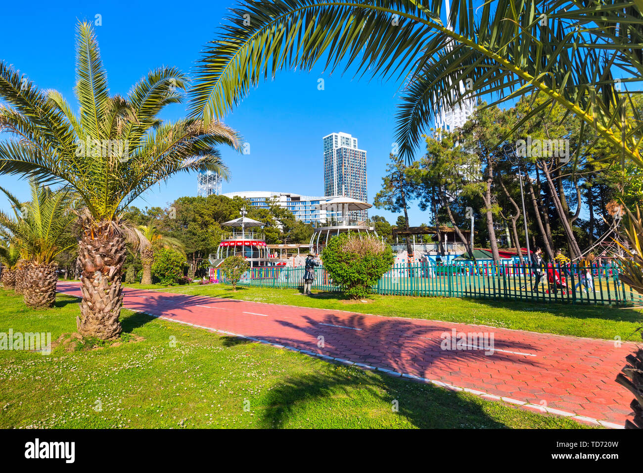 Batumi, Georgia - 30 Aprile 2017: la gente camminare nel parco con palme vicino al promenade boulevard di georgian summer resort Foto Stock