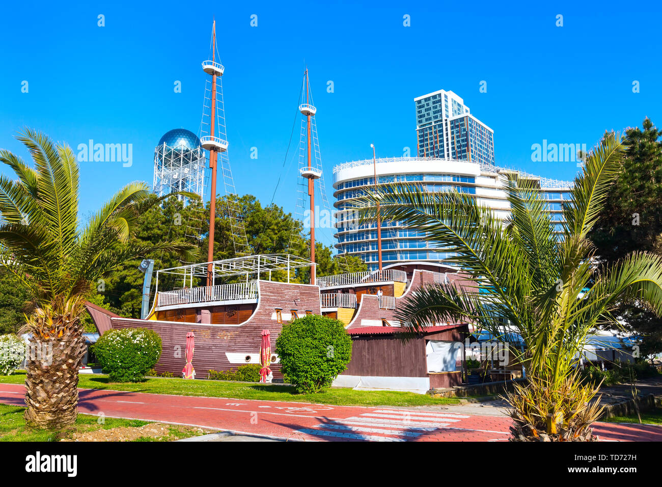 Parco con palme, nave e case moderne vicino al promenade boulevard di georgian summer resort Foto Stock