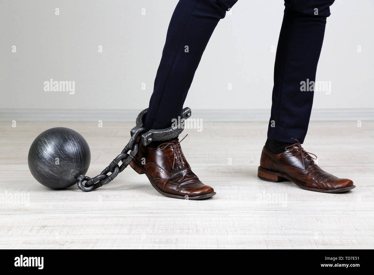 Lavoratore aziendale con la palla e la catena attaccata al piede Foto Stock