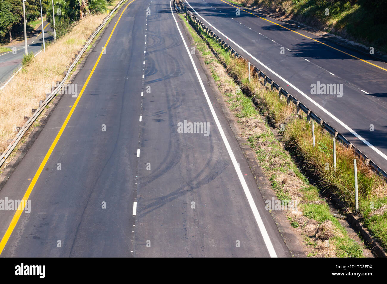 Autostrada strada nuova sezione di asfalto catrame dipinto di bianco linee su due corsie overhead medio dettaglio foto. Foto Stock