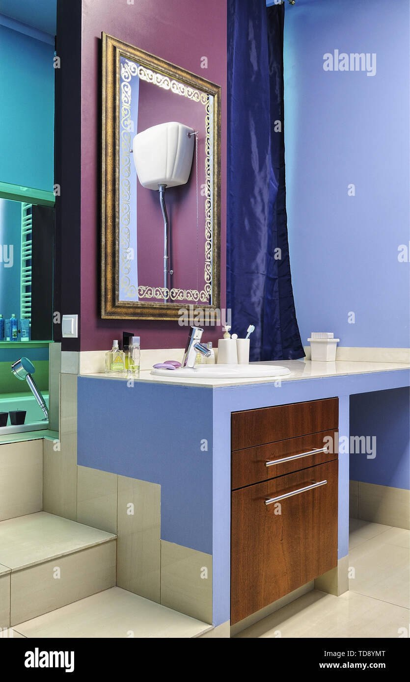 Grande specchio sopra il lavabo accanto a gradini che portano alla vasca da bagno UK & IRISH UTILIZZARE SOLO Foto Stock