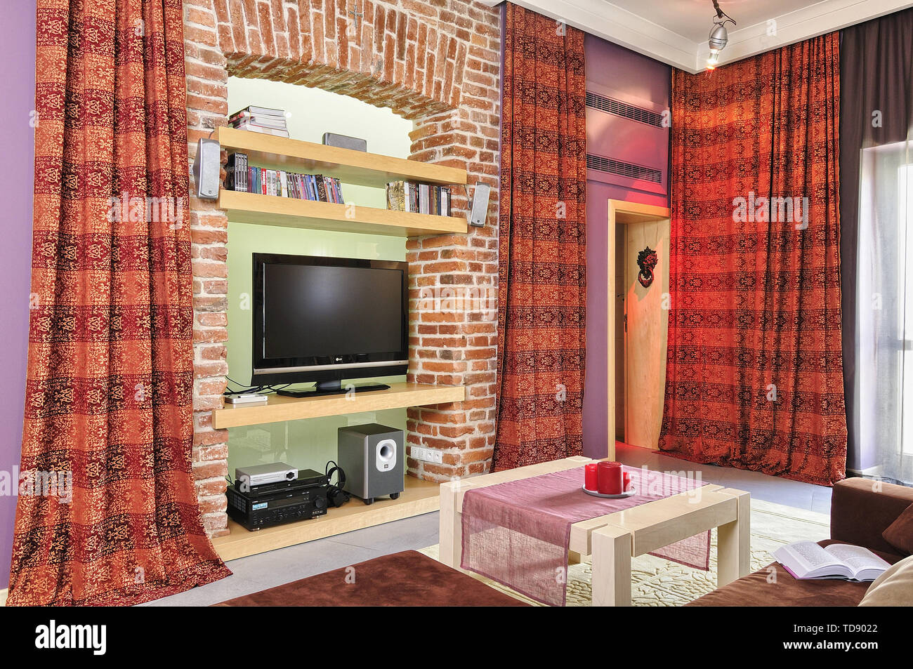 TV e audio video attrezzature incassato in un muro di mattoni di scaffali in soggiorno moderno britannico e irlandese solo diritti Foto Stock