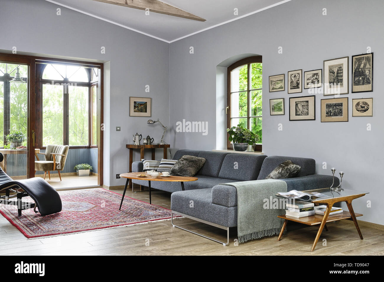 Tabella di caffè di fronte divano grigio in uno spazioso soggiorno con vista al conservatorio UK & IRISH UTILIZZARE SOLO Foto Stock