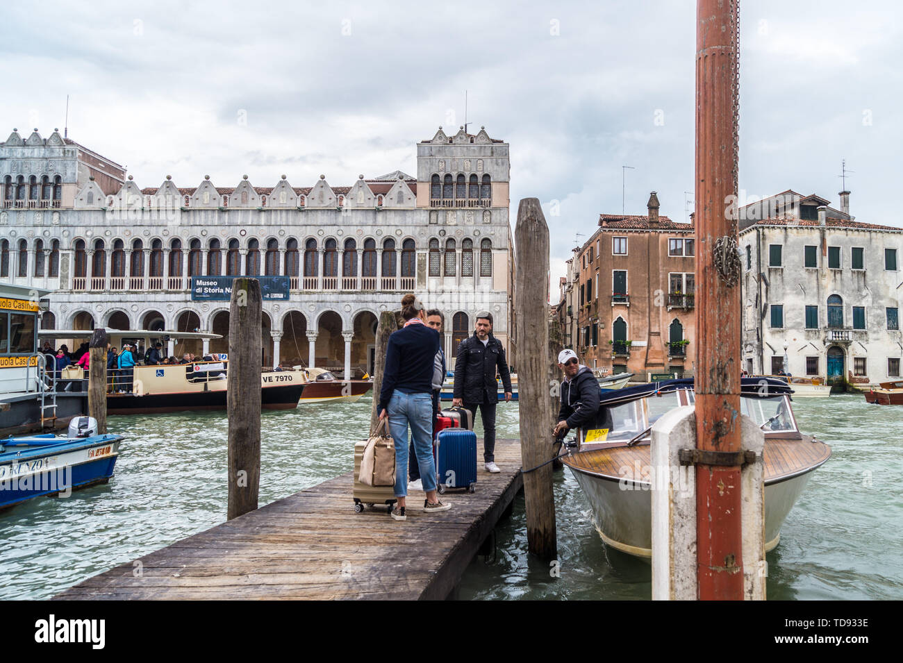 I passeggeri di salire a bordo di un taxi acqueo a San Marcuola pier sul Canal Grande di fronte Fondaco dei Turchi, ora al Museo di Storia Naturale di Venezia Veneto Italia Foto Stock