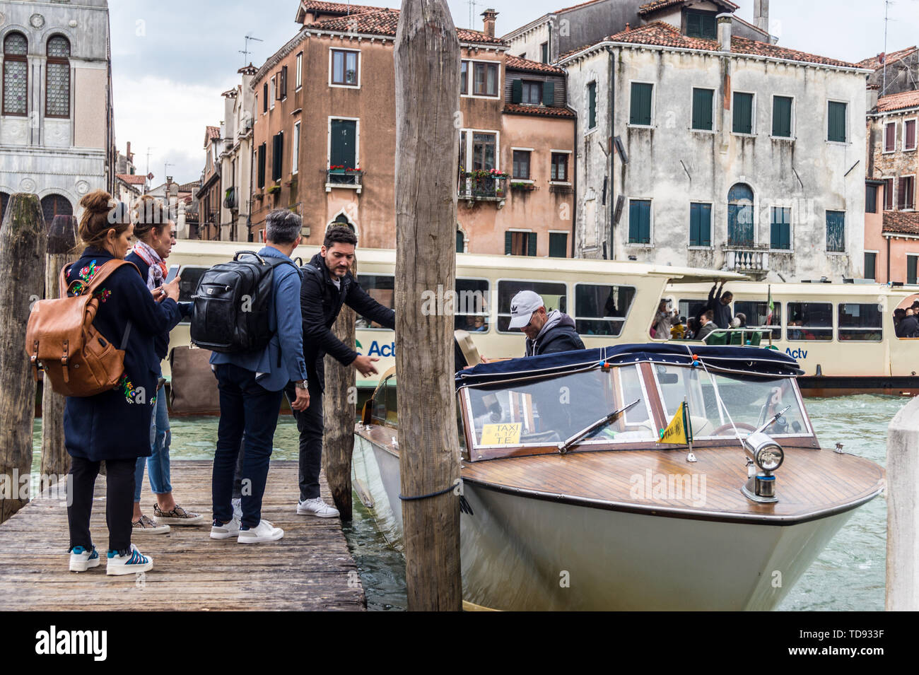 I passeggeri di salire a bordo di un taxi acqueo a San Marcuola pier sul Canal Grande di fronte Fondaco dei Turchi, ora al Museo di Storia Naturale di Venezia Veneto Italia Foto Stock