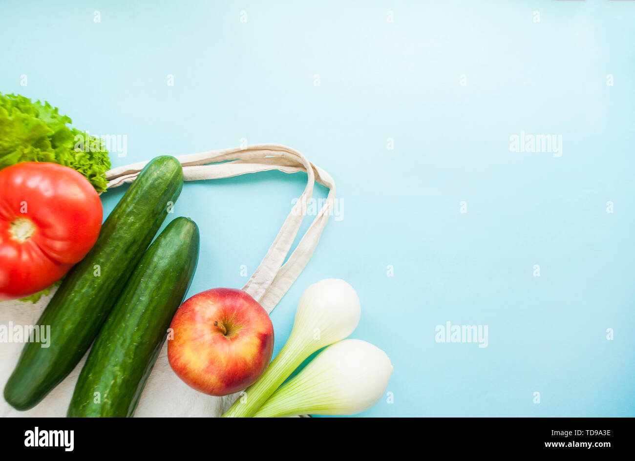 La frutta e la verdura fresca in eco borsa sul colore turchese sfondo con copyspace. Rifiuti Zero concetto. Foto Stock