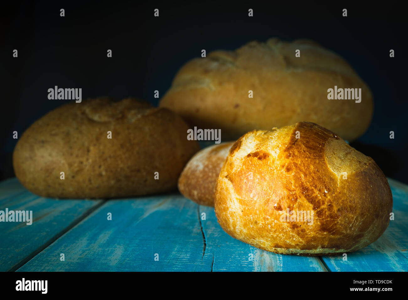 Il pane su una tabella con il colore blu e il pane in blur, da dietro Foto Stock