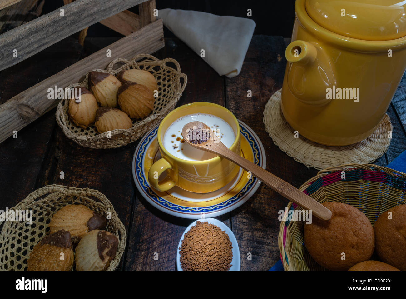 Caffè con latte e pasticcini serviti su un vecchio tavolo in legno Foto Stock