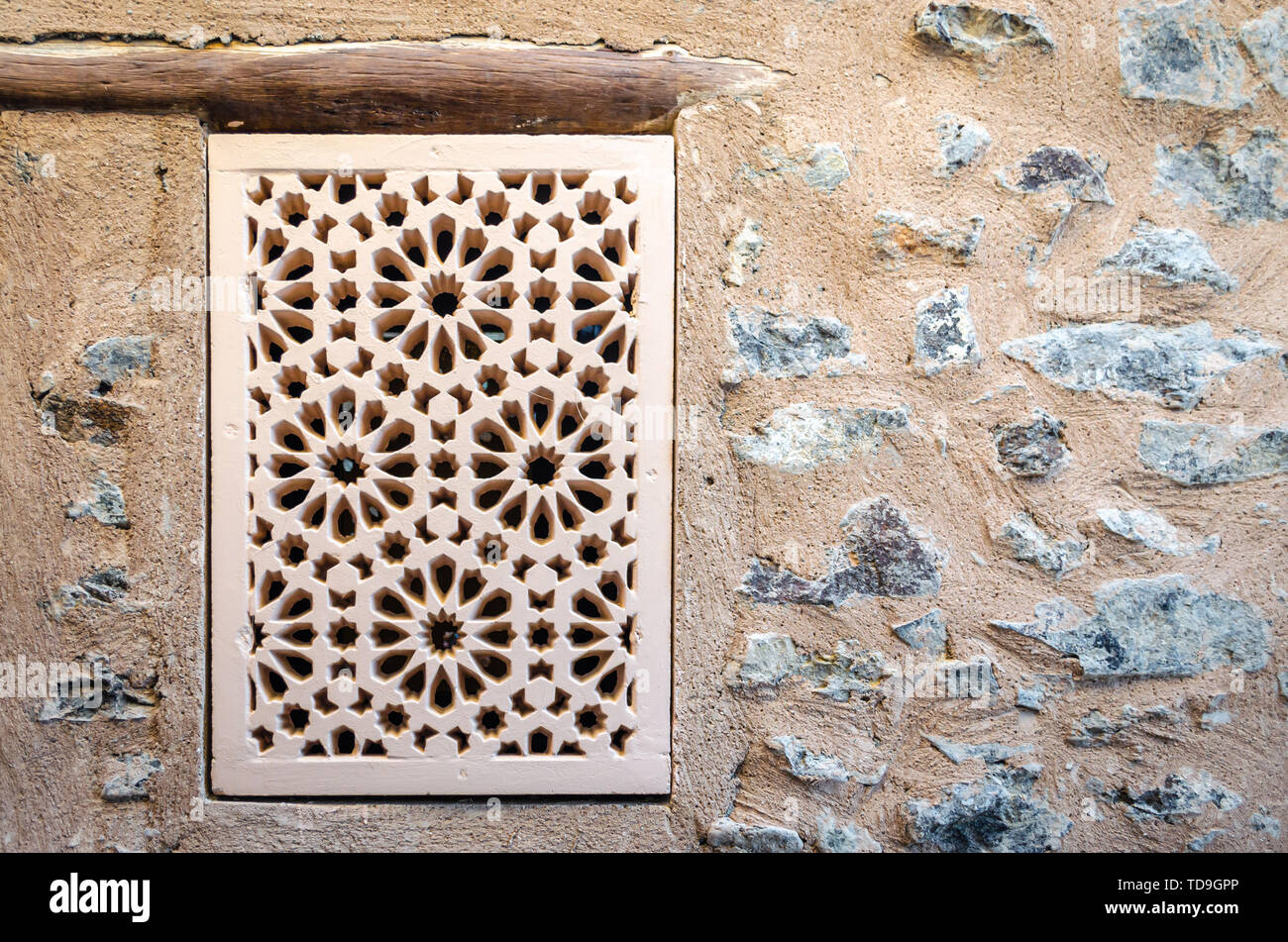 Vecchio & Artigianato tradizionale finestra di pattern su un muro di pietra. Da Fort Muttrah, Muscat Oman. Foto Stock