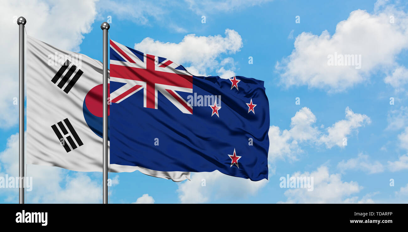 La Corea del Sud e Nuova Zelanda bandiera sventolare nel vento contro bianco torbido cielo blu insieme. Concetto di Diplomazia e relazioni internazionali. Foto Stock