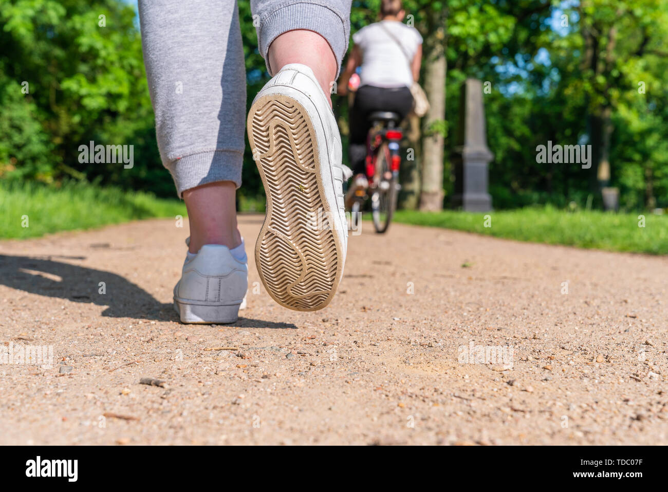 Scarpa da corsa di un pareggiatore femmina preso da dietro in un parco Foto Stock