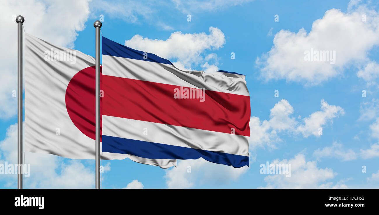 Il Giappone e la Costa Rica bandiera sventolare nel vento contro bianco torbido cielo blu insieme. Concetto di Diplomazia e relazioni internazionali. Foto Stock