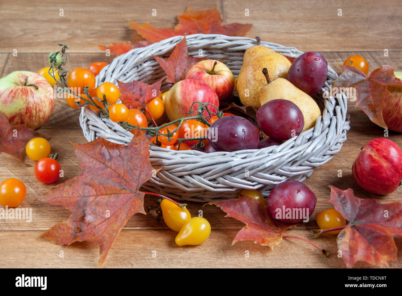 Autunno ancora in vita. Vari frutti e foglie di autunno sono giacenti in un cesto di vimini. Doni della natura. Foto Stock