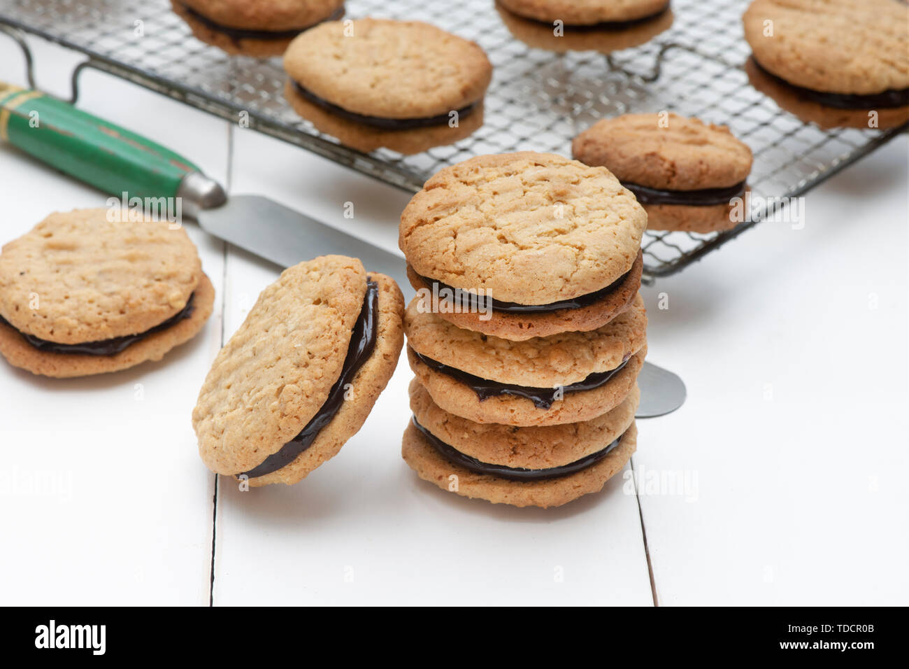 In casa kingston biscotti. Australian biscotto. Round di cocco e avena biscotti frollini con crema di cioccolato in medio Foto Stock