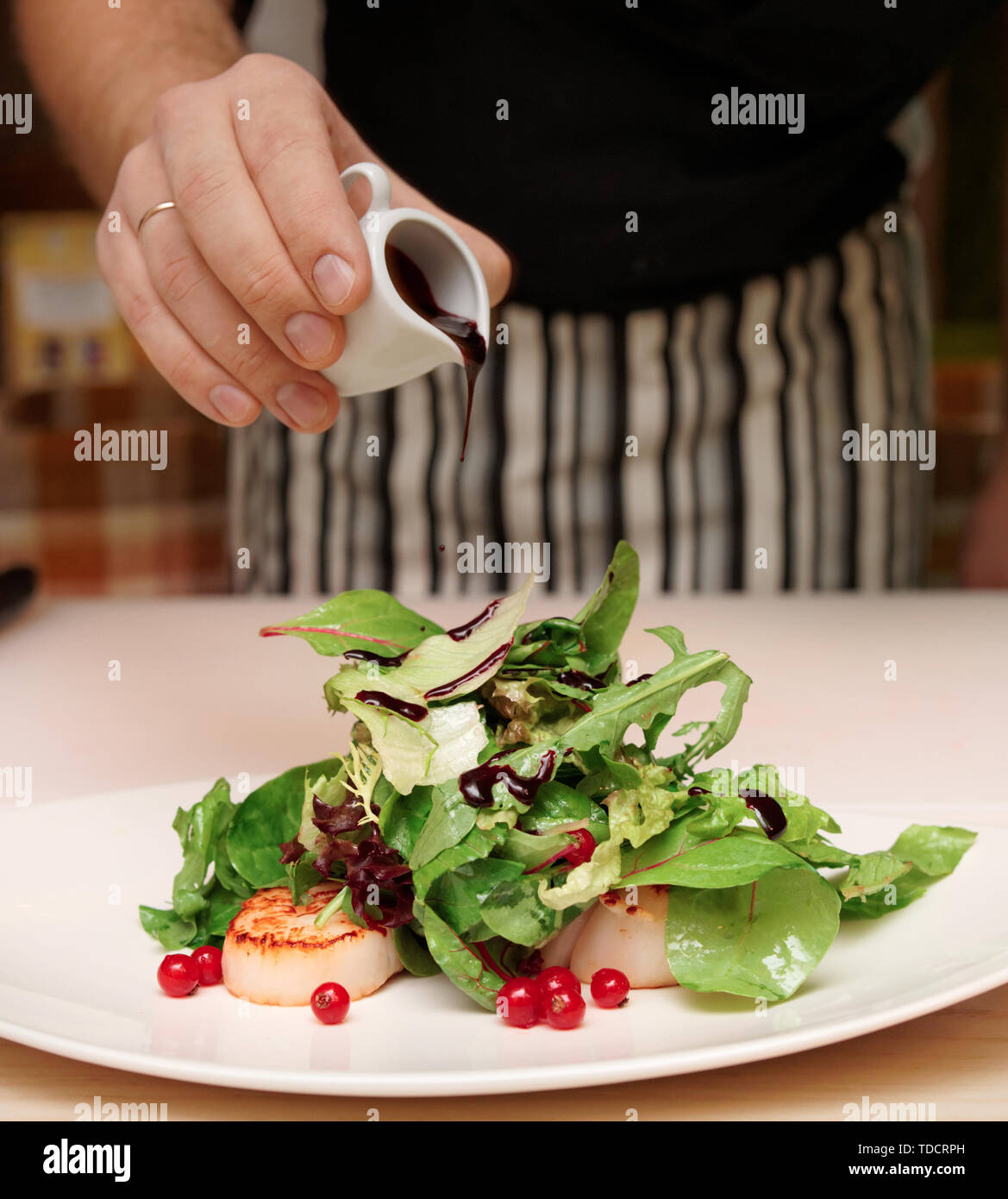 Lo chef è aggiunta di aceto in antipasto con capesante Foto Stock