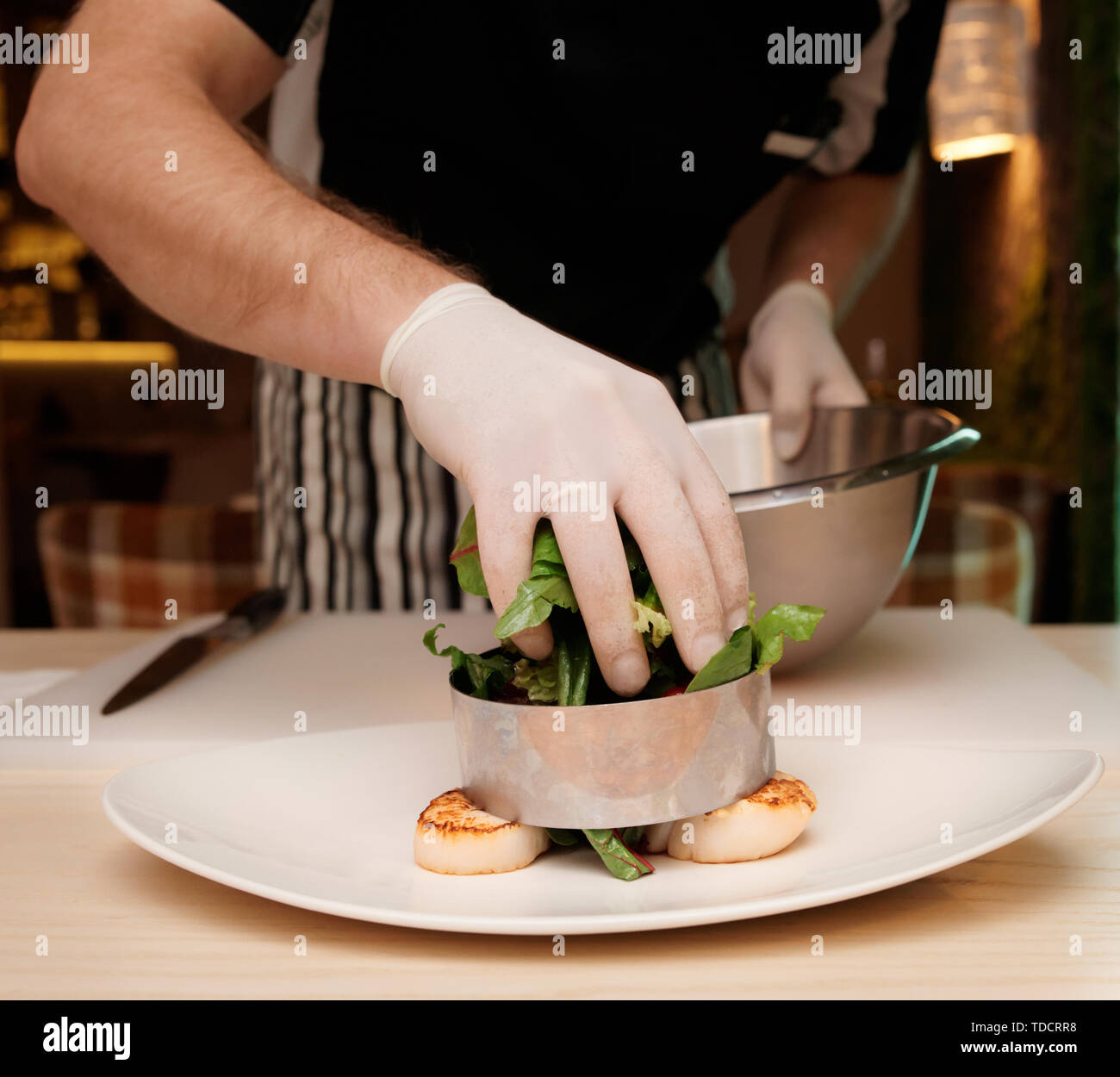 Professopnal chef è la cottura di antipasto con capesante Foto Stock