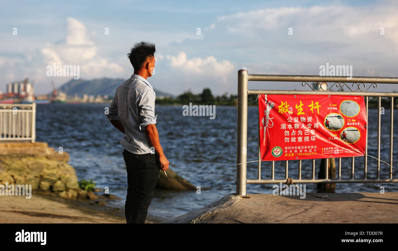 Il traghetto sul fiume, l'uomo di fumare una sigaretta in attesa per il traghetto. Io sono qui in attesa che il vento per attendere Foto Stock