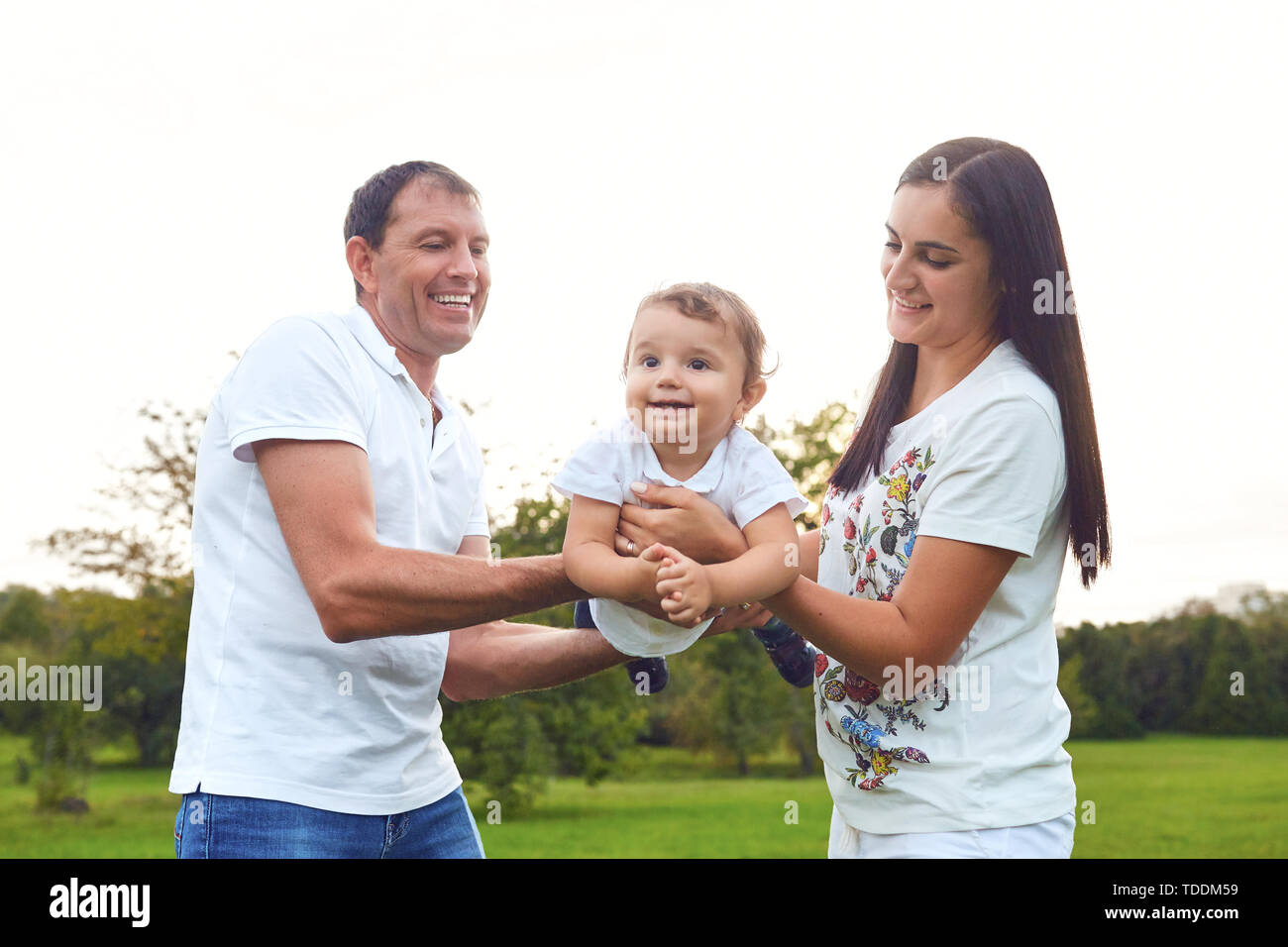 La famiglia felice giocando con il bambino nel parco. Foto Stock