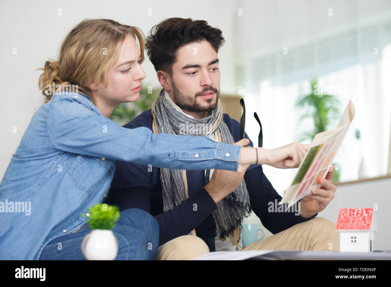 Coppia giovane cerca attraverso brochure e di progettare il loro futuro Foto Stock