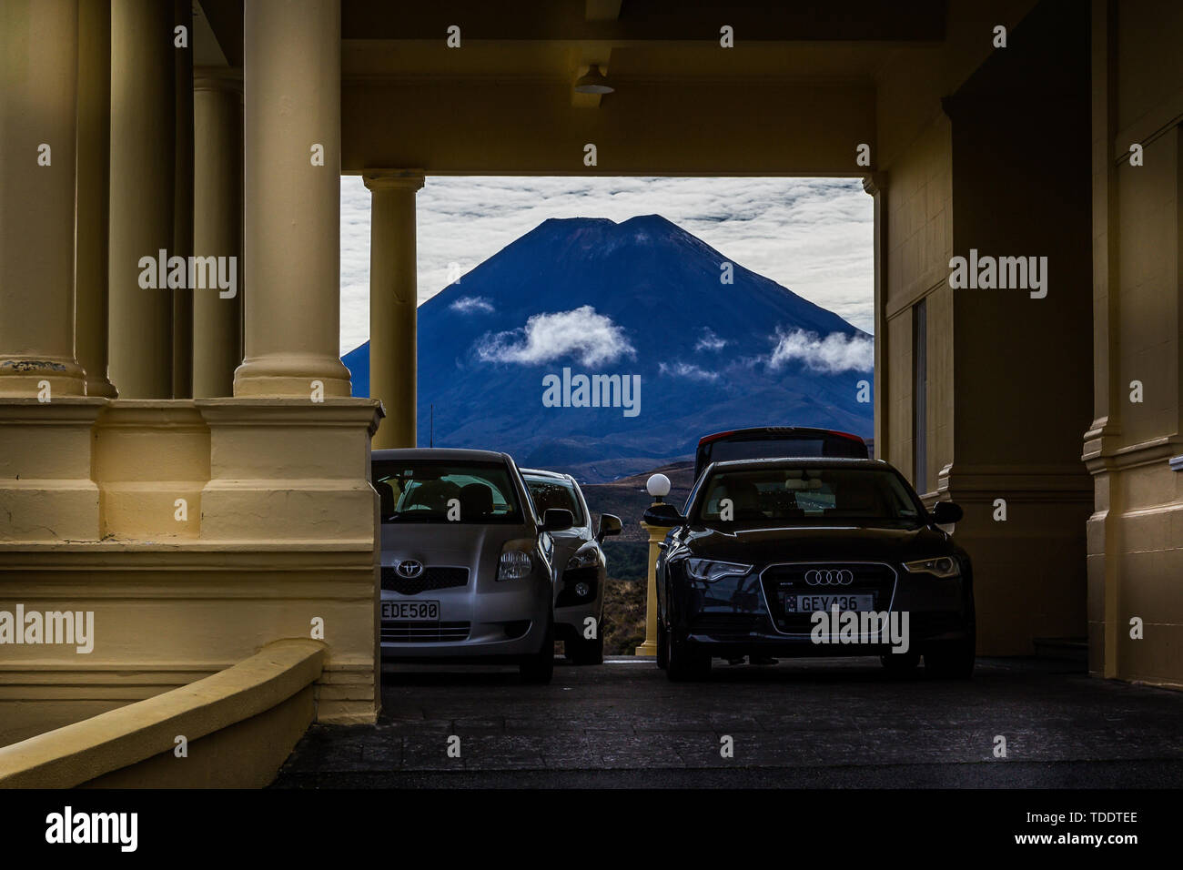 Auto parcheggiata di fronte Chateau Tongariro con vulcanico Monte Ruapehu incorniciato in background nel Parco Nazionale di Tongariro, Nuova Zelanda il 29 febbraio 2012 Foto Stock