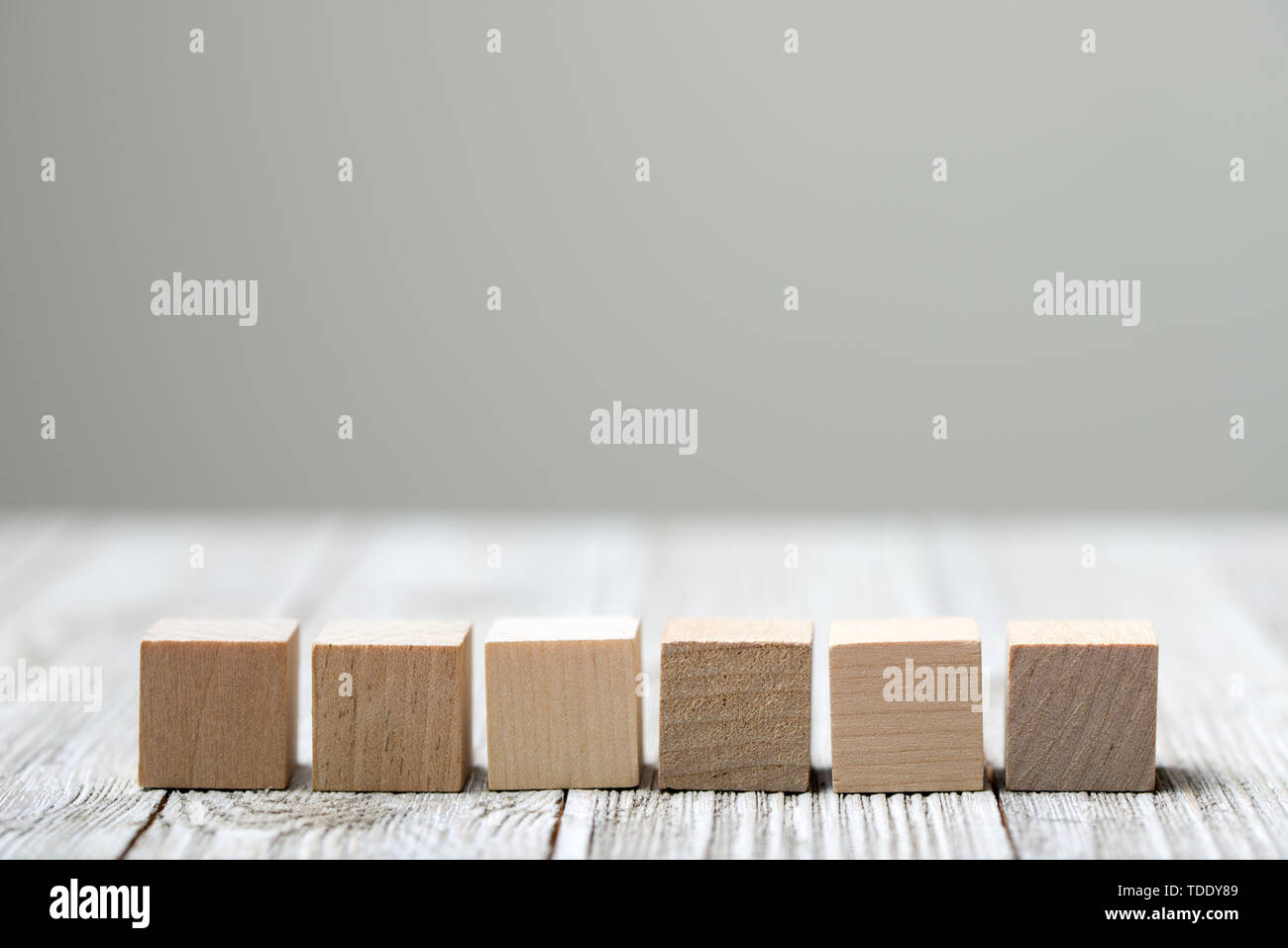 Sei giocattolo di legno i cubi su grigio Sfondo di legno Foto Stock