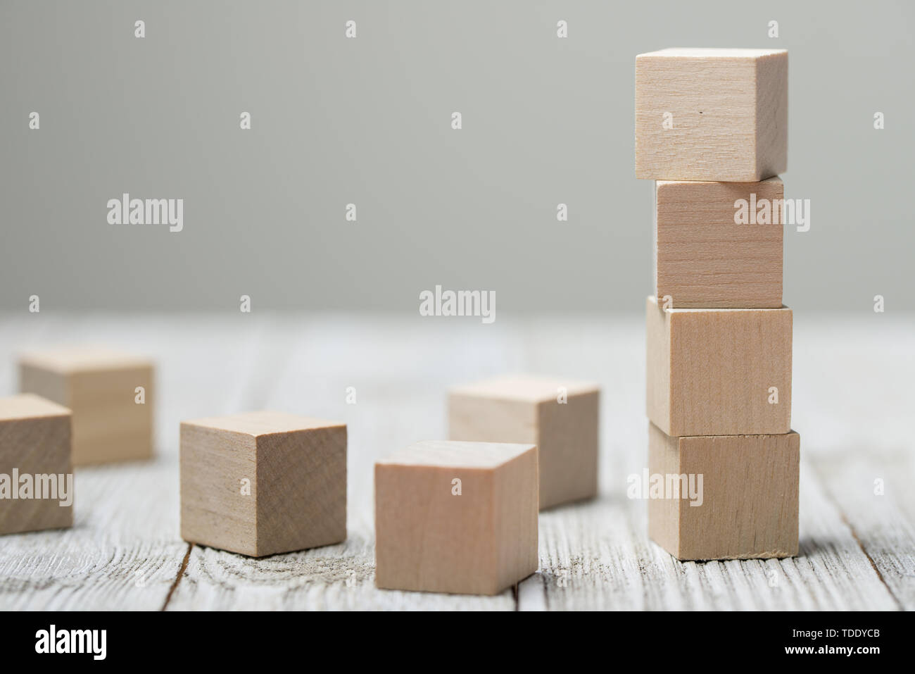 Quattro giocattolo di legno i cubi su grigio Sfondo di legno Foto Stock