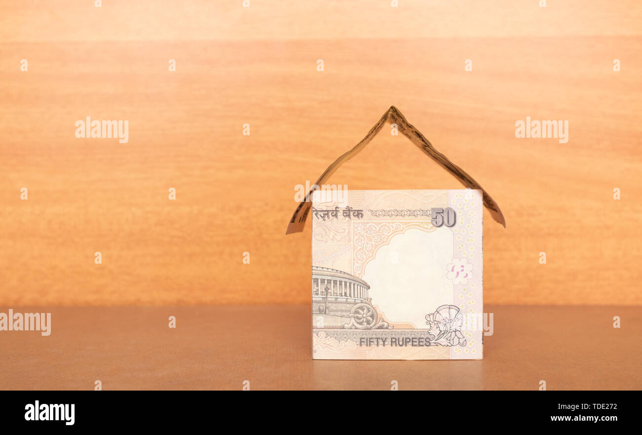 Casa fatta dalla valuta indiana con copia spazio, concetto di costruzione di casa con il denaro Foto Stock