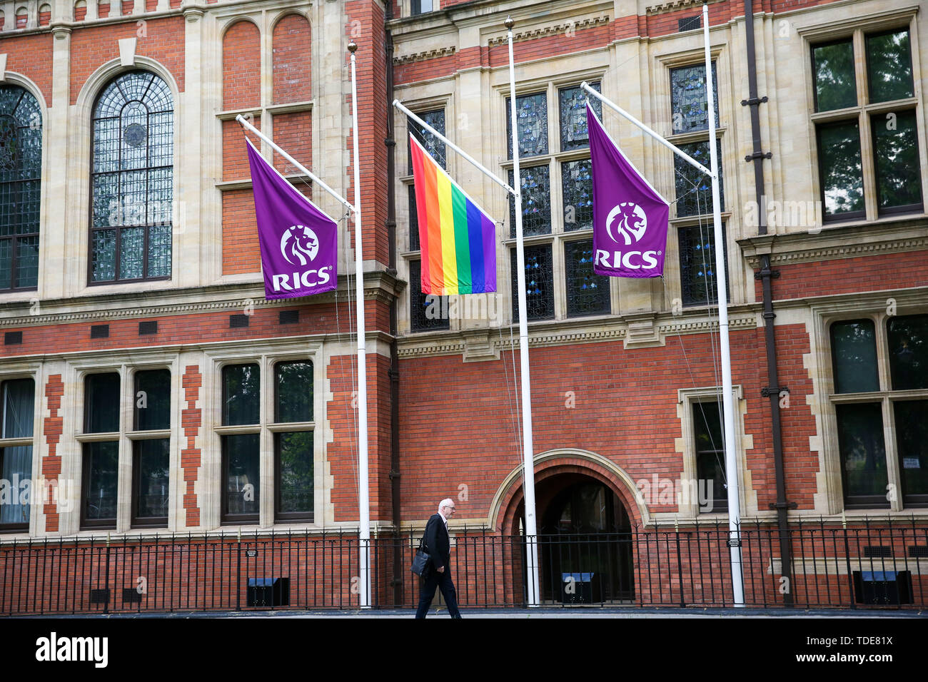 Un orgoglio bandiera si blocca in tra RICS bandiere al di fuori del Royal Institution of Chartered Surveyors (RICS ) edificio nel centro di Londra nella celebrazione di orgoglio a Londra il prossimo mese. Foto Stock