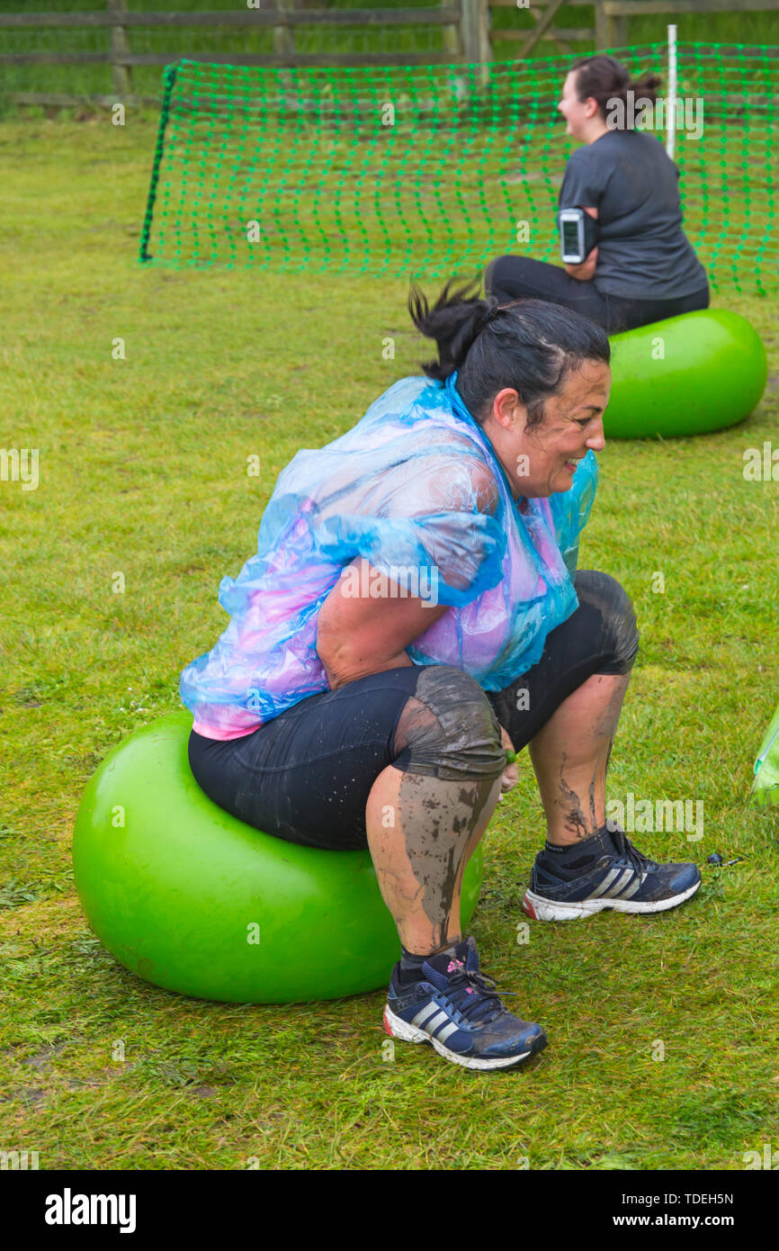 Baiter Park, Poole, Dorset, Regno Unito. Il 15 giugno 2019. Freddo umido giorno di gara per la vita piuttosto fangoso dove le donne, molti vestiti in rosa, unisciti alla lotta per sconfiggere il cancro e raccogliere fondi a favore della ricerca sul cancro del Regno Unito, il superamento degli ostacoli in tutto il 5km di corso e divertirsi sempre coperto di fango. Divertimento sulla spacehoppers! Credito: Carolyn Jenkins/Alamy Live News Foto Stock
