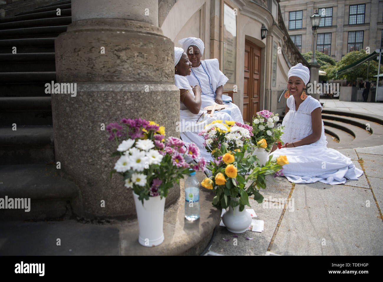Berlino, Germania. Il 15 giugno, 2019. Durante l'ottava notte lunga di religioni, membri del candomblé Berlino parrocchia di sedersi di fronte alla Chiesa francese al Gendarmenmarkt. Una preoccupazione comune della partecipazione delle comunità religiose di quest anno è la gestione della risorsa. Il motto è quindi "acqua di vita". Credito: Jörg Carstensen/dpa/Alamy Live News Foto Stock